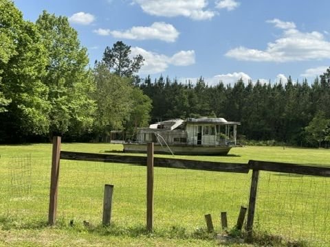 Gambrel-roof home with a long driveway near Starke